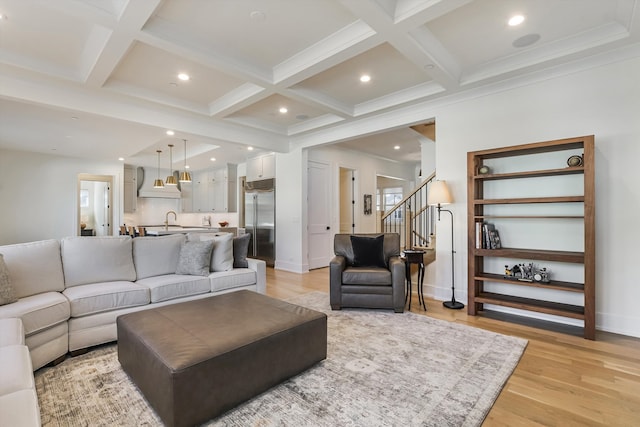 living area with light wood-type flooring, beam ceiling, coffered ceiling, recessed lighting, and stairs