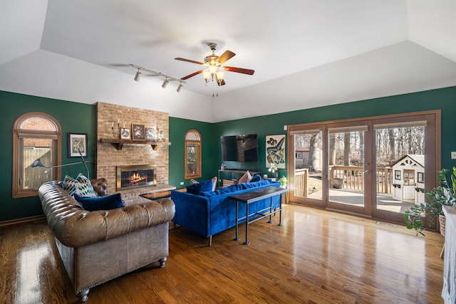 living area featuring ceiling fan, lofted ceiling, and wood finished floors