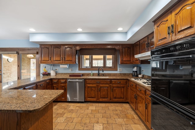 kitchen with white gas cooktop, a sink, under cabinet range hood, dobule oven black, and stainless steel dishwasher