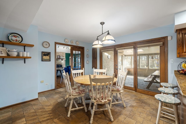 dining area with french doors, baseboards, and stone tile flooring