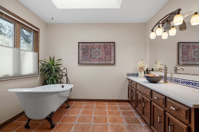 full bath featuring a skylight, vanity, and baseboards