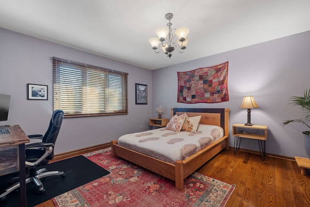 bedroom with baseboards, wood finished floors, and a chandelier