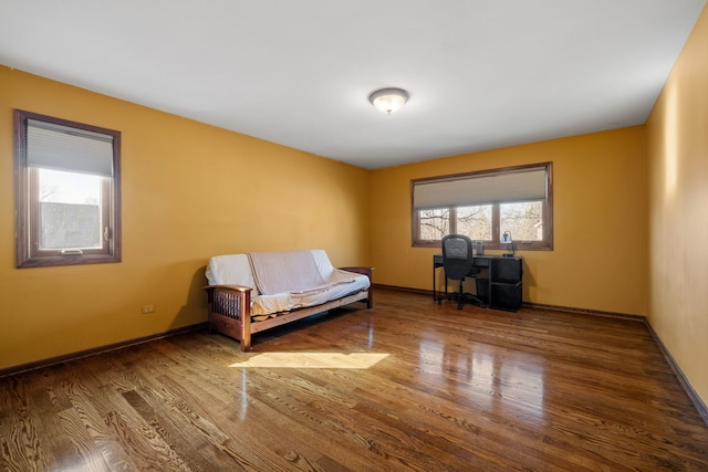 living area featuring baseboards and wood finished floors