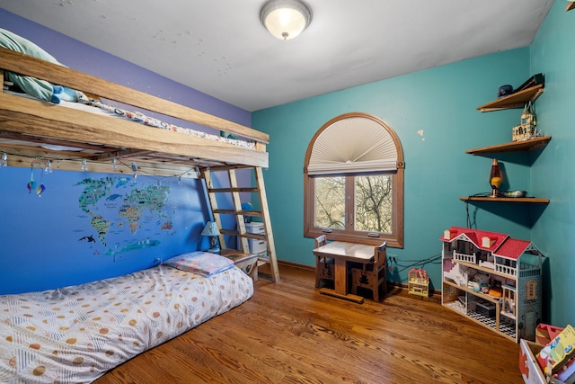 bedroom with baseboards and wood finished floors