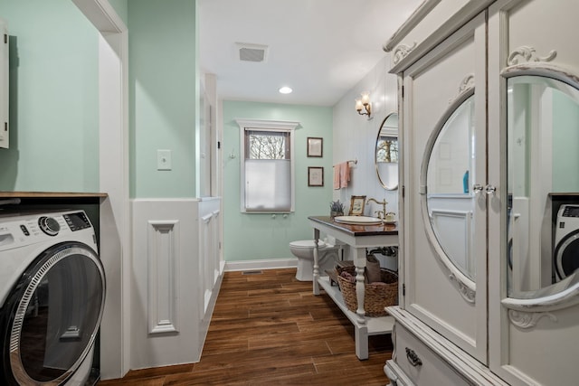 clothes washing area with dark wood-style floors, baseboards, visible vents, washer / clothes dryer, and a sink