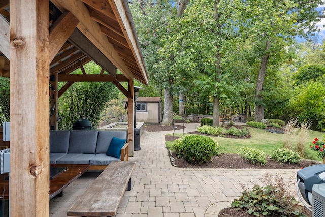 view of patio featuring outdoor lounge area, an outdoor structure, a gazebo, and a storage unit