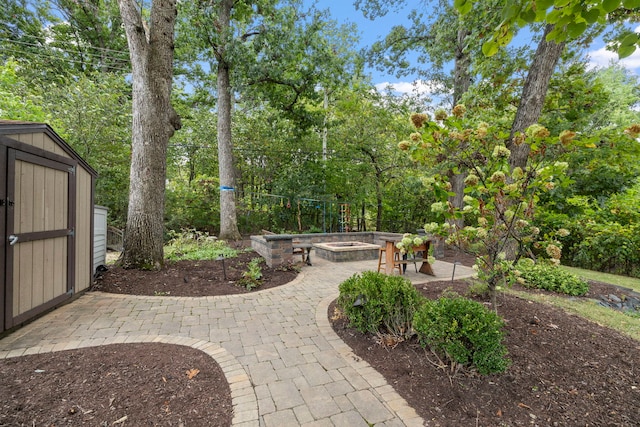 view of yard featuring a patio area, a shed, a fire pit, and an outbuilding