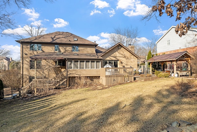 rear view of house featuring roof with shingles, a gazebo, a lawn, a chimney, and a sunroom