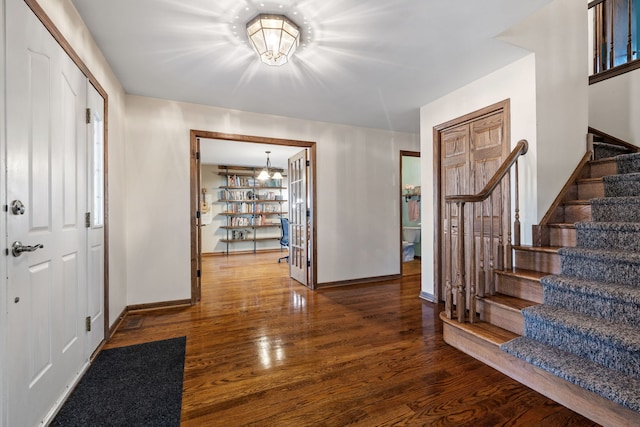 foyer entrance featuring stairway, wood finished floors, and baseboards