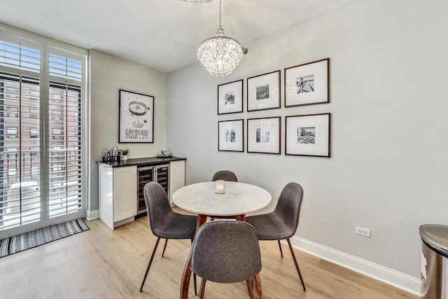 dining room featuring a wealth of natural light, a notable chandelier, and light wood-type flooring