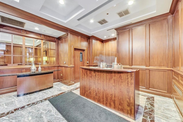 kitchen with a center island, visible vents, wood walls, and brown cabinets