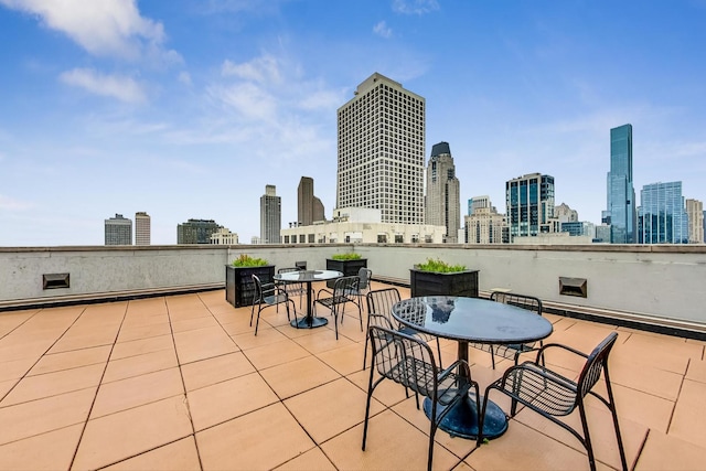 view of patio with outdoor dining area and a city view