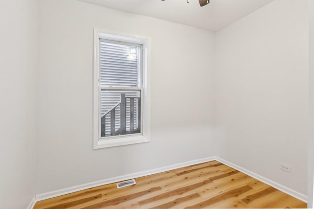 empty room featuring a ceiling fan, baseboards, visible vents, and light wood finished floors