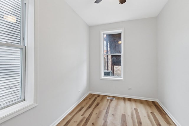 unfurnished room featuring light wood-style flooring, baseboards, visible vents, and ceiling fan