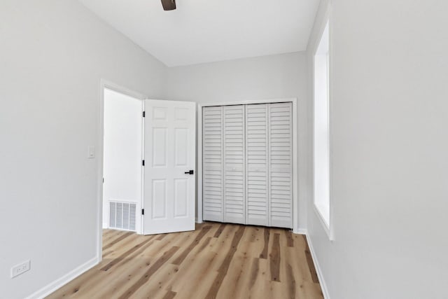 unfurnished bedroom featuring a closet, visible vents, baseboards, and light wood-style floors