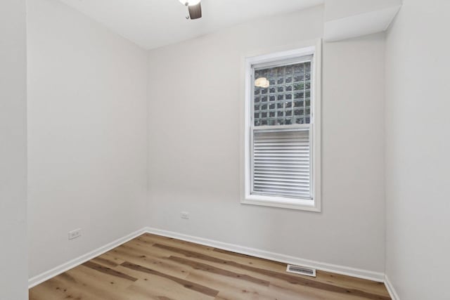 spare room featuring visible vents, baseboards, and wood finished floors