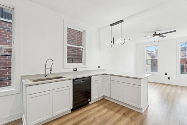 kitchen with light wood-style flooring, a sink, black dishwasher, a peninsula, and ceiling fan