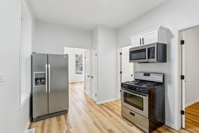 kitchen featuring visible vents, baseboards, appliances with stainless steel finishes, light wood-style floors, and white cabinets