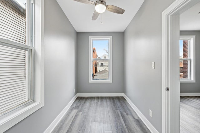 unfurnished room featuring wood finished floors, baseboards, and ceiling fan