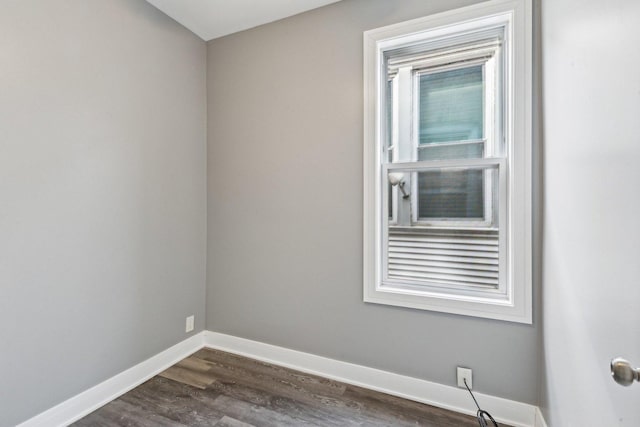 empty room with baseboards and dark wood finished floors