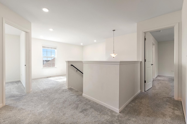 corridor featuring recessed lighting, an upstairs landing, baseboards, and light carpet