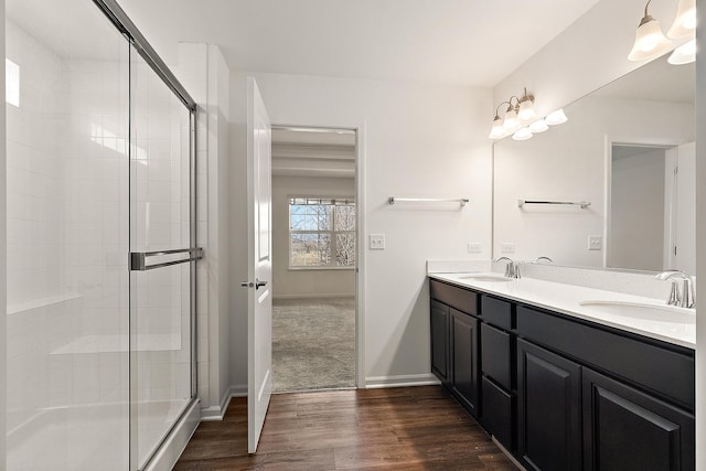 full bath featuring wood finished floors, a stall shower, and a sink