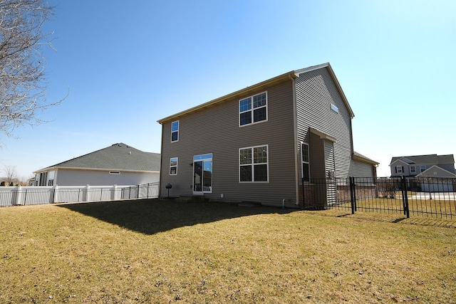 back of house featuring a lawn and fence