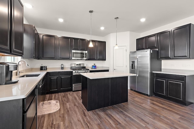 kitchen with a sink, a kitchen island, stainless steel appliances, light countertops, and dark wood-style flooring