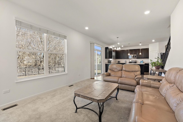 living room with baseboards, visible vents, recessed lighting, light carpet, and a notable chandelier