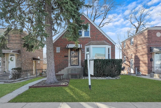 tudor home featuring a front lawn and brick siding