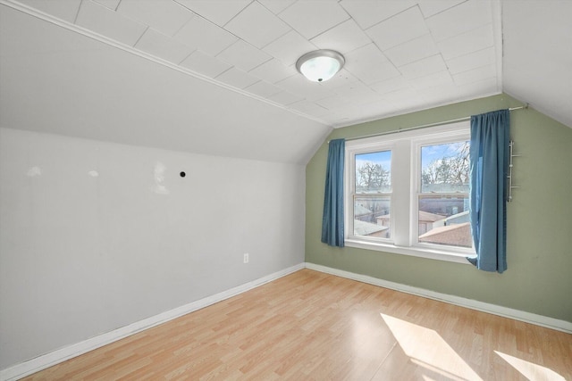 bonus room featuring baseboards, wood finished floors, and vaulted ceiling