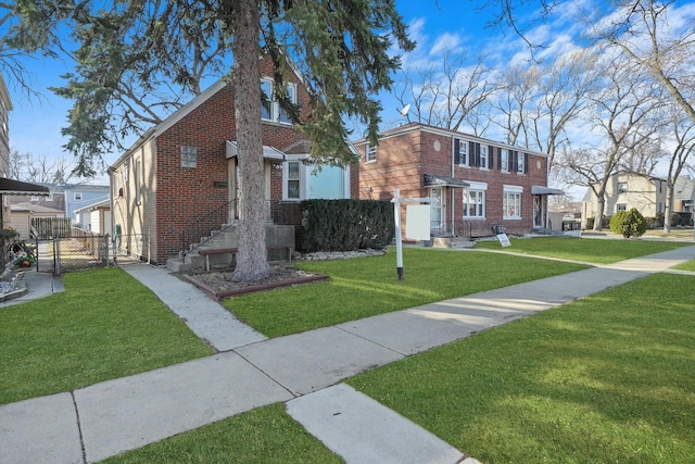 view of front facade with brick siding, a front lawn, and a gate