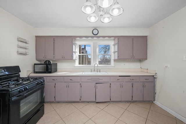 kitchen featuring light tile patterned floors, a sink, black appliances, light countertops, and a notable chandelier