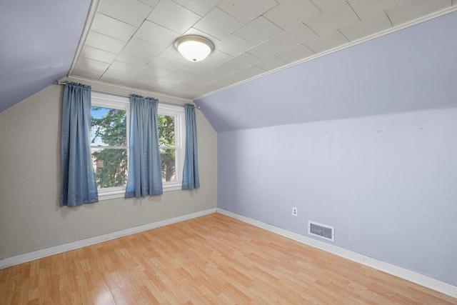 bonus room with visible vents, baseboards, lofted ceiling, and wood finished floors