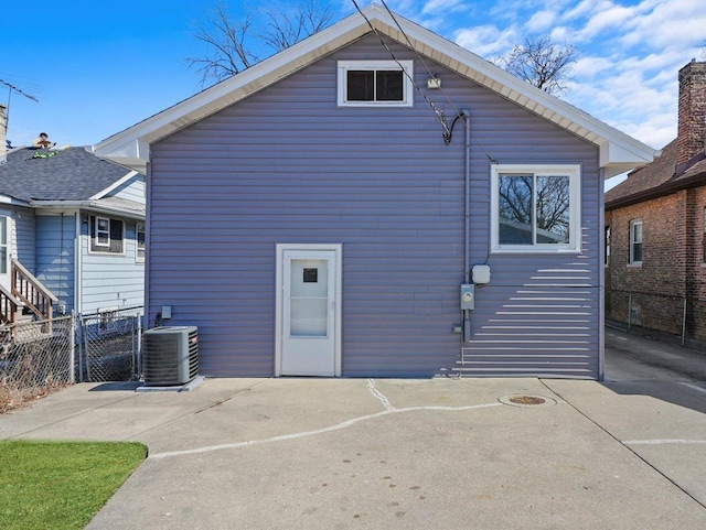 back of house featuring central AC and fence