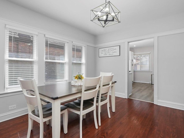 dining area featuring wood finished floors, baseboards, and a chandelier