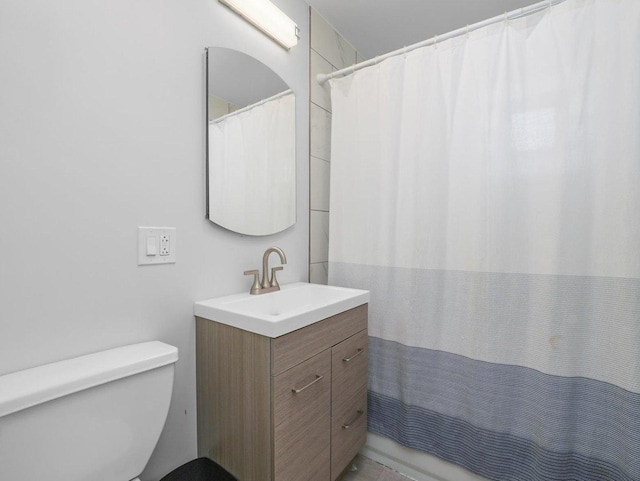 full bathroom featuring a shower with shower curtain, toilet, and vanity