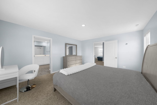 carpeted bedroom featuring visible vents and connected bathroom