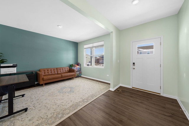 foyer featuring baseboards and wood finished floors