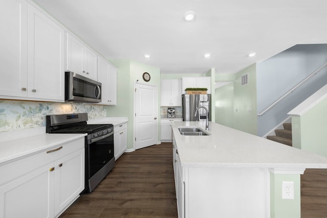 kitchen featuring visible vents, a sink, tasteful backsplash, appliances with stainless steel finishes, and white cabinets