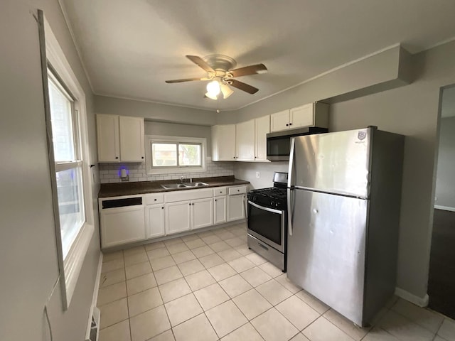 kitchen with dark countertops, tasteful backsplash, ceiling fan, appliances with stainless steel finishes, and a sink