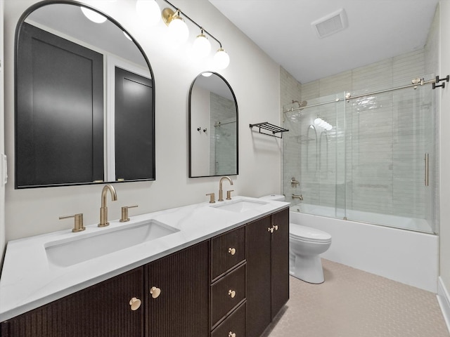 full bathroom featuring visible vents, toilet, a sink, double vanity, and enclosed tub / shower combo