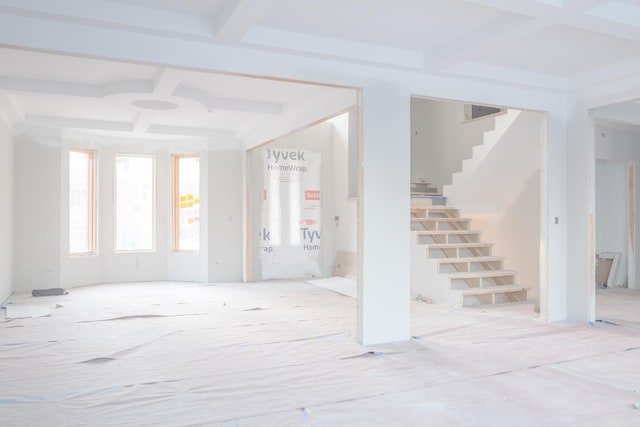 foyer entrance with coffered ceiling, stairs, and beam ceiling