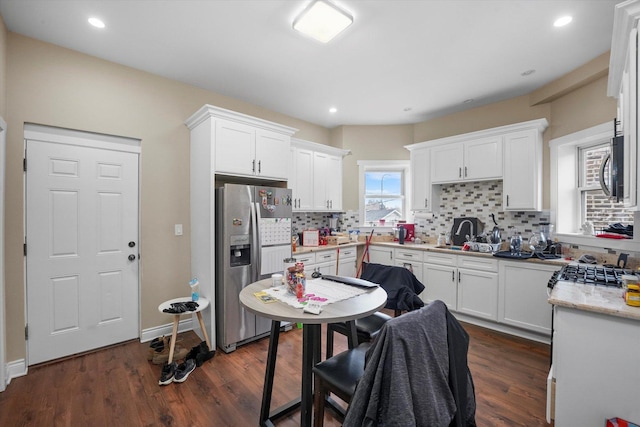 kitchen with white cabinetry, decorative backsplash, and stainless steel appliances