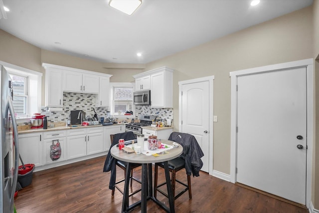 kitchen with stainless steel appliances, white cabinets, and decorative backsplash