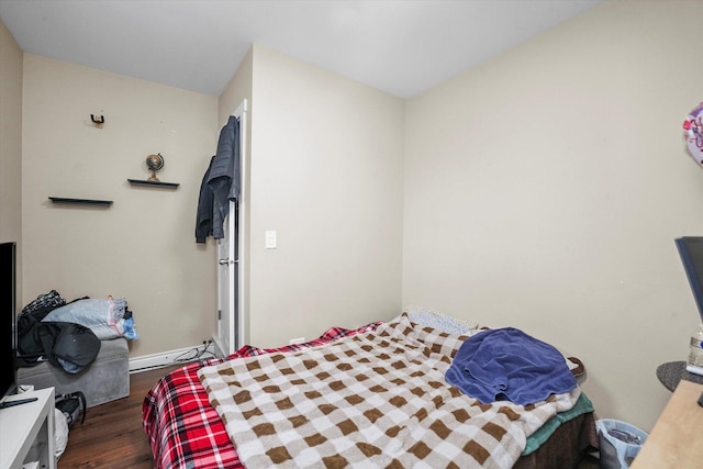 bedroom featuring baseboards, baseboard heating, and wood finished floors