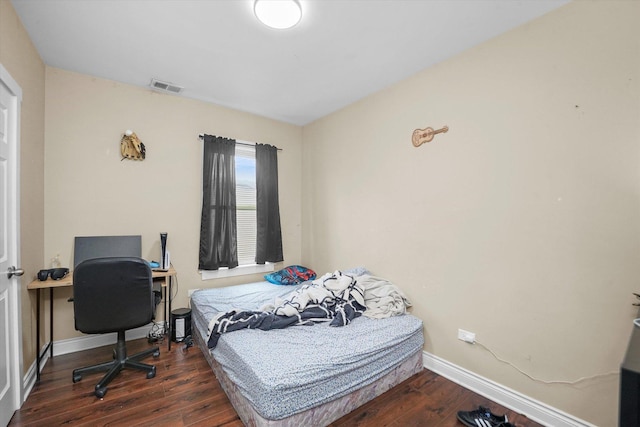 bedroom with visible vents, baseboards, and dark wood-style flooring