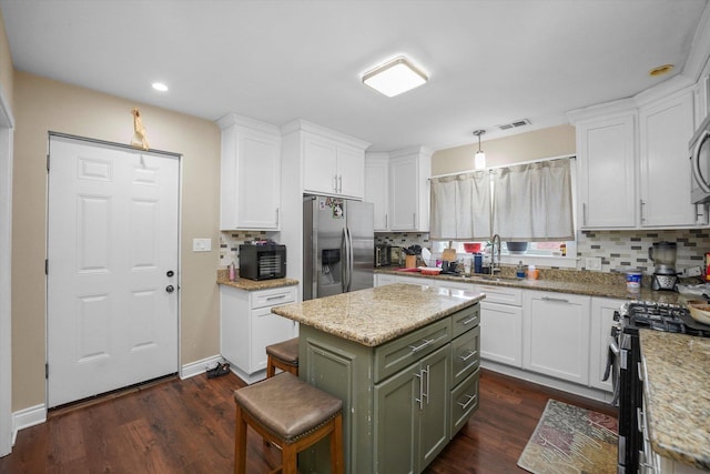 kitchen featuring dark wood finished floors, appliances with stainless steel finishes, and white cabinetry