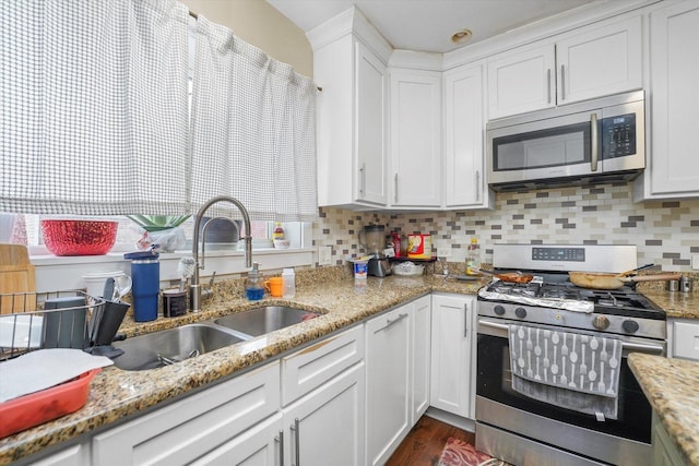 kitchen featuring a sink, white cabinets, tasteful backsplash, and stainless steel appliances