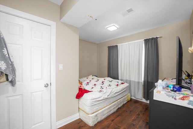 bedroom featuring baseboards, visible vents, and dark wood-style flooring